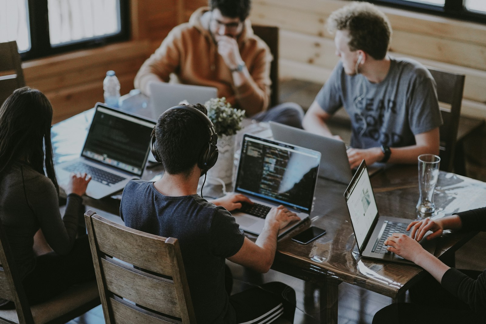 A team of colleagues building together on laptops at a FNDR company hackathon